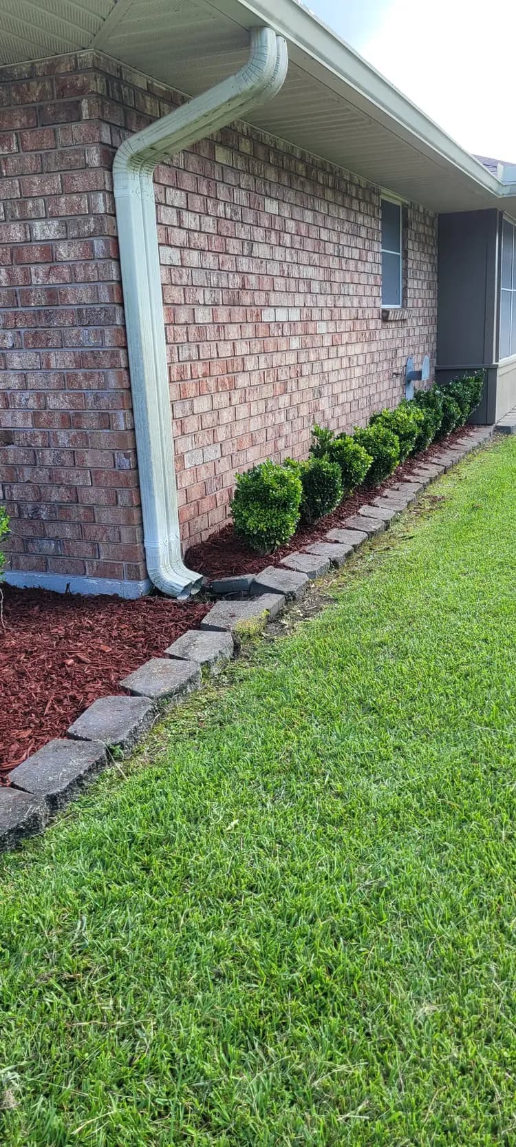 Manicured front yard estate lawn with sharp driveway edging in Denham Springs