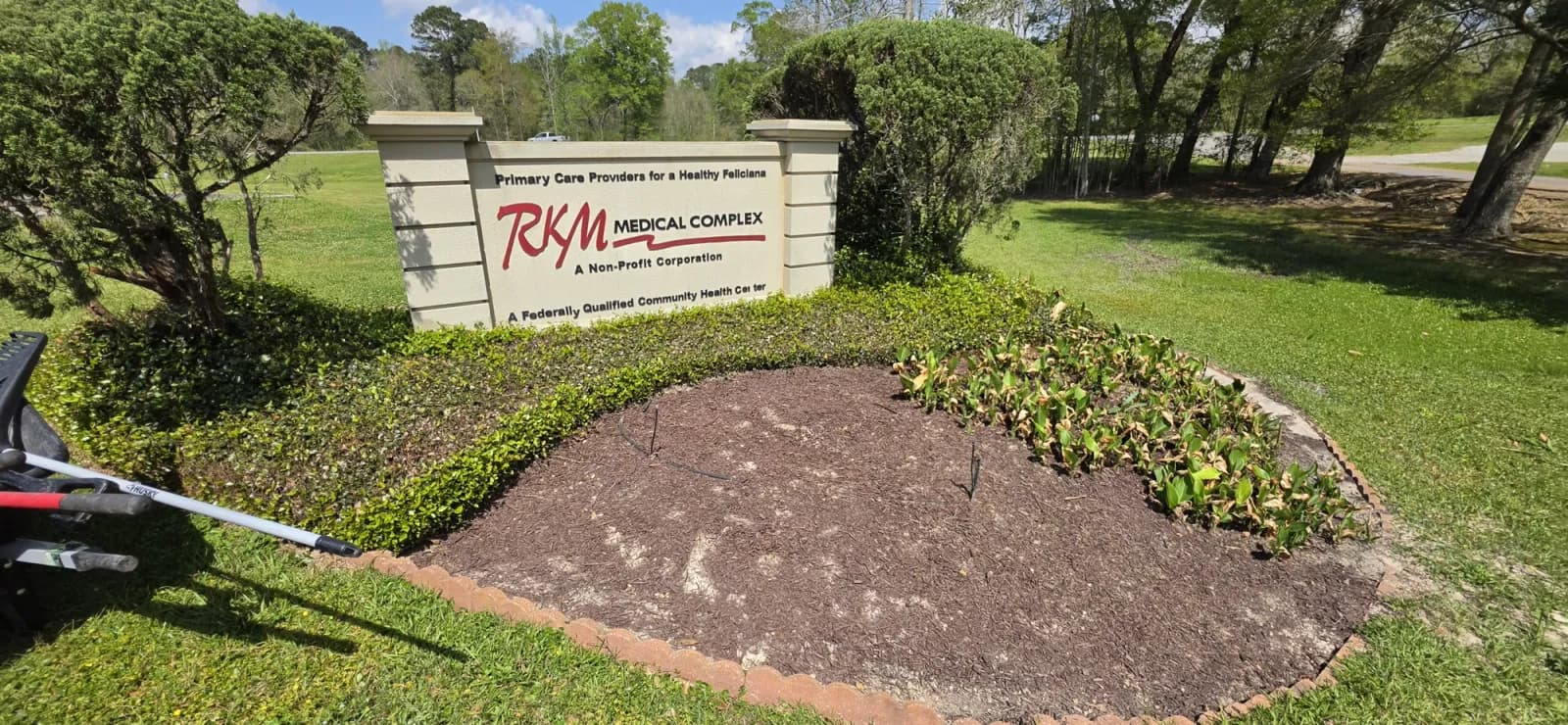 Fresh brown mulch being installed in the RKM Medical Complex entrance bed with brick edging.