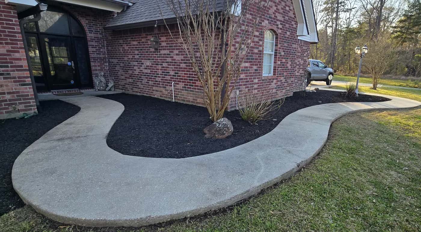 After: curved flower bed in Walker, LA finished with fresh black mulch around a crape myrtle next to the front walk.